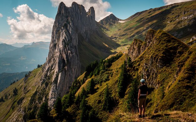 Vue arrière d'un garçon debout sur les montagnes contre le ciel