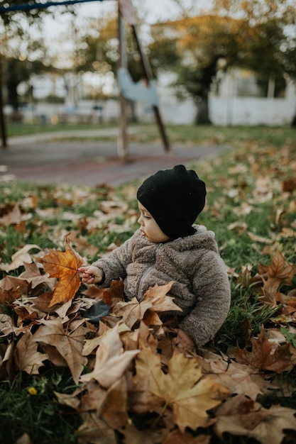 Vue arrière d'un garçon sur des feuilles sèches sur un champ