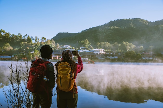 Vue arrière des gens regardant le lac contre le ciel