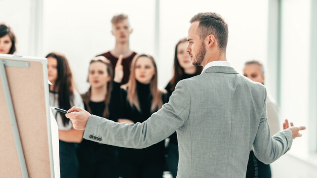 Vue arrière. Gestionnaire sérieux pointant sur le flipchart. affaires et éducation