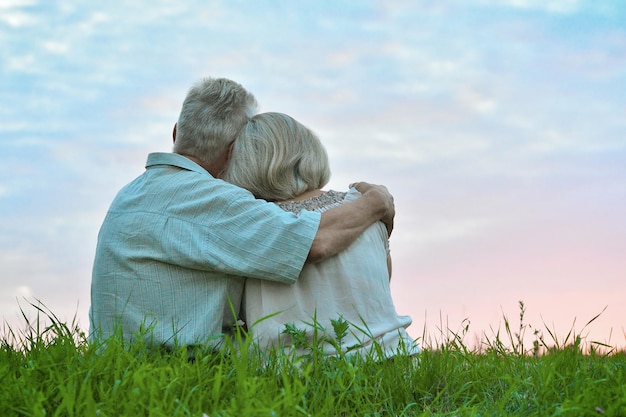 Vue arrière Heureux couple de personnes âgées au coucher du soleil