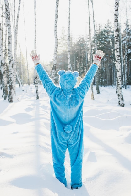 Vue arrière d'un homme adulte debout sur un champ couvert de neige dans la forêt