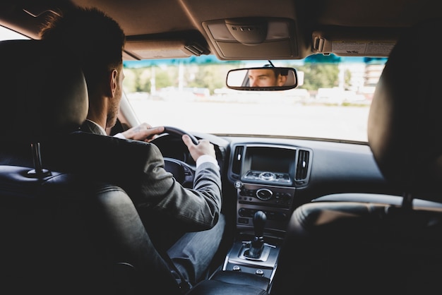 Vue arrière, de, homme affaires, conduire voiture