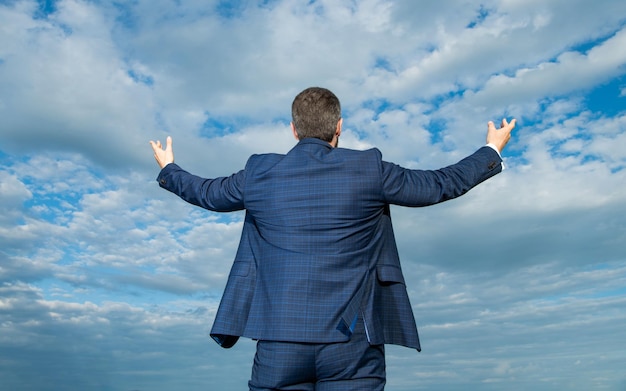 Vue arrière de l'homme d'affaires prospère professionnel en costume sur fond de ciel