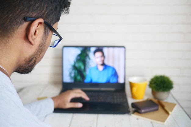 Vue arrière de l'homme d'affaires en vidéoconférence discuter de stratégie