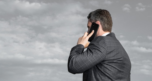 Vue arrière de l'homme a une conversation téléphonique espace de copie en plein air l'homme a une conversation téléphonique porter un costume