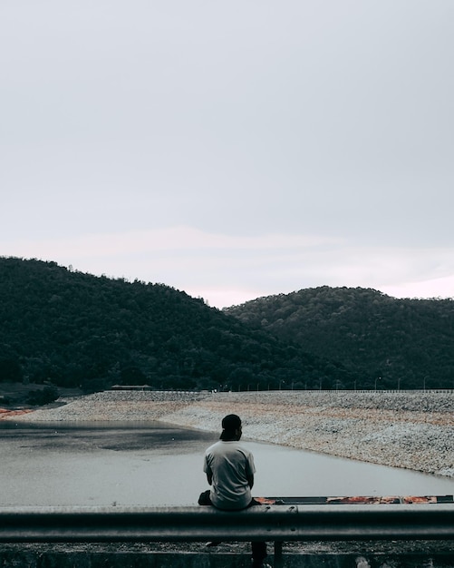 Photo vue arrière d'un homme debout dans la vue latérale du barrage