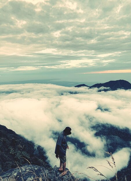 Photo vue arrière d'un homme debout sur une montagne contre le ciel au coucher du soleil