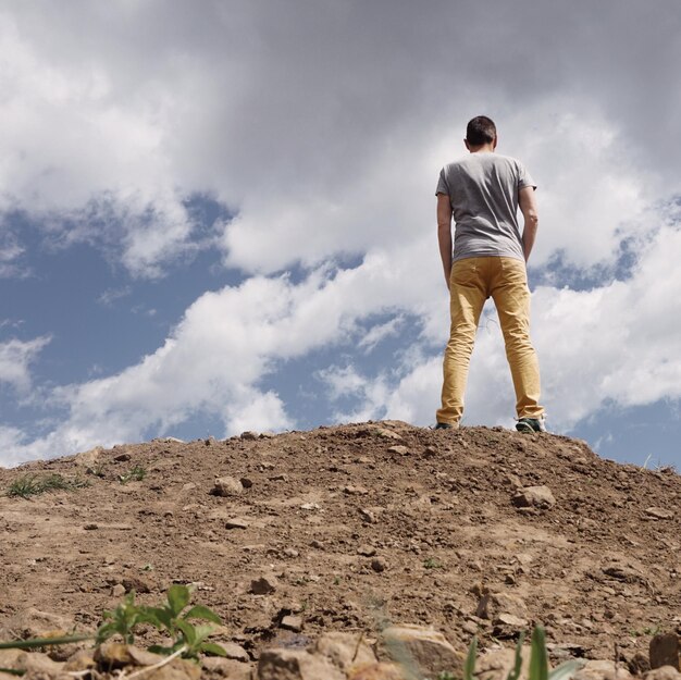 Photo vue arrière d'un homme debout sur une montagne contre le ciel