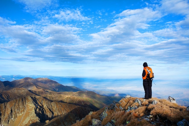 Vue arrière d'un homme debout sur une montagne contre le ciel
