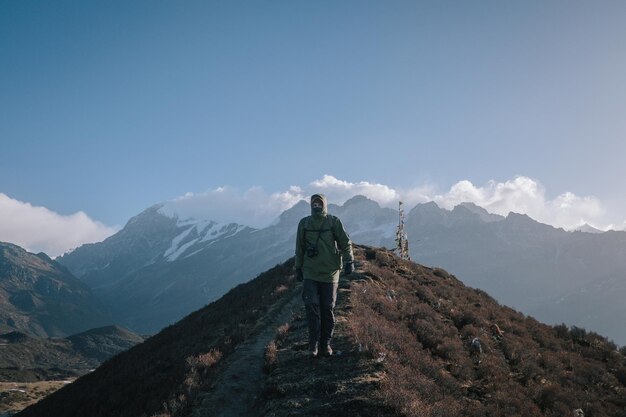 Vue arrière d'un homme debout sur une montagne contre le ciel