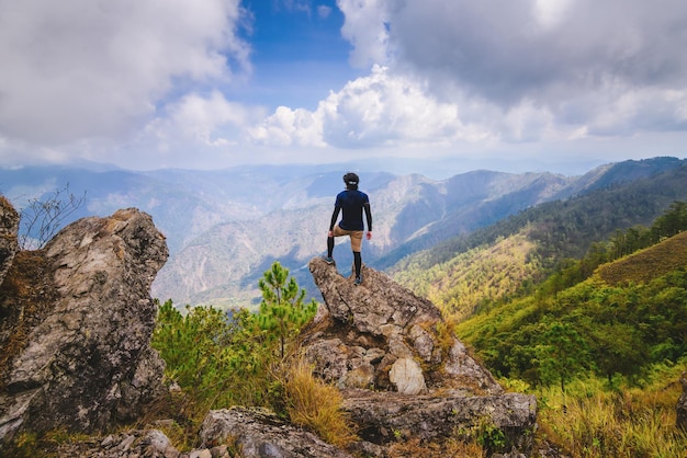 Vue arrière d'un homme debout sur un rocher contre une chaîne de montagnes