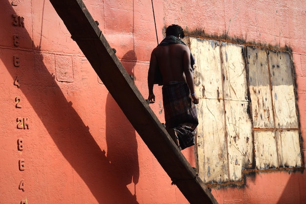 Vue arrière d'un homme descendant l'escalier par le mur