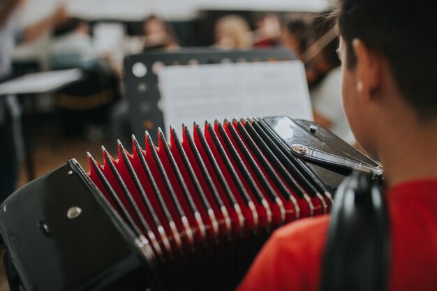 Photo vue arrière d'un homme jouant de l'accordéon dans une école de musique