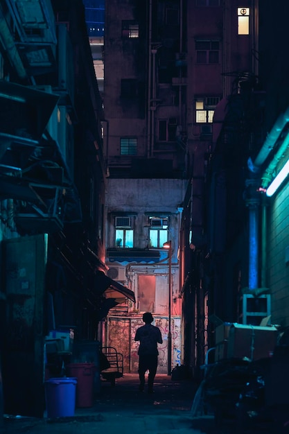 Vue arrière d'un homme marchant dans une ruelle au milieu des bâtiments de la ville
