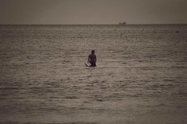 Photo vue arrière de l'homme sur la mer contre le ciel