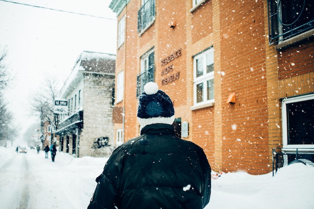 Vue arrière de l'homme sur la neige en ville