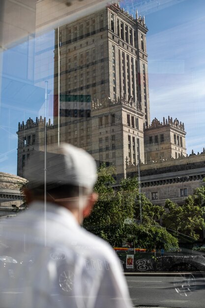 Vue arrière d'un homme regardant des bâtiments contre le ciel dans la ville