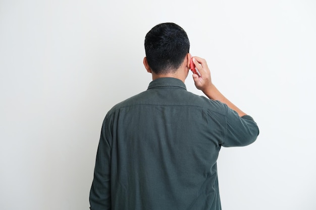 Vue arrière d'un homme répondant à un appel téléphonique