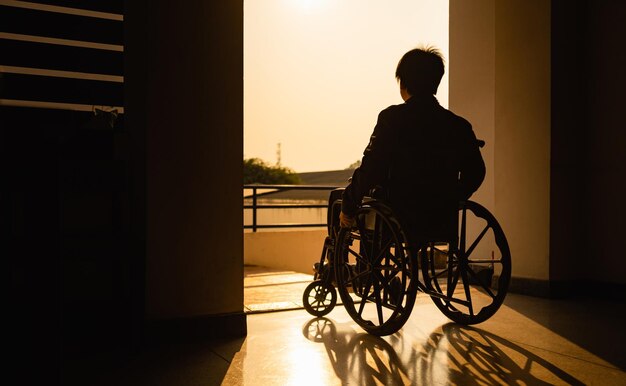 Vue arrière d'un homme en silhouette assis dans un fauteuil roulant