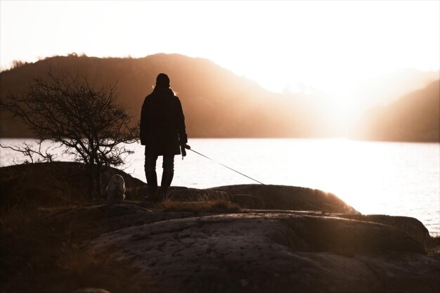 Photo vue arrière de l'homme en silhouette debout sur la montagne contre le ciel