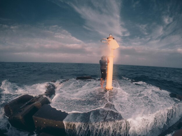 Photo vue arrière d'un homme surplombant la mer calme