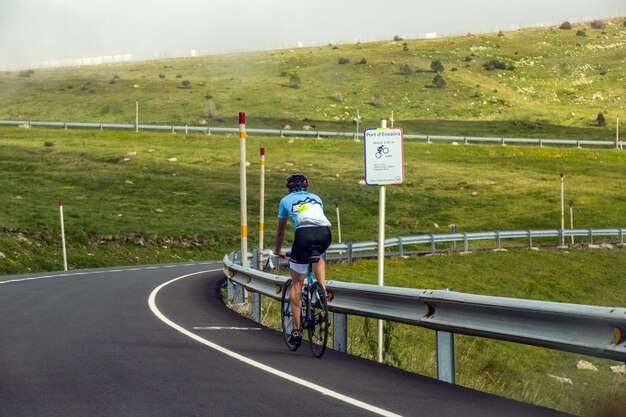 Photo vue arrière d'un homme à vélo sur la route