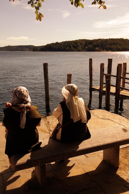 Photo vue arrière d'hommes assis sur un banc près du lac