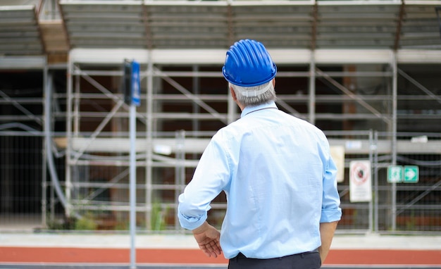 Photo vue arrière d'un ingénieur en regardant un bâtiment en construction