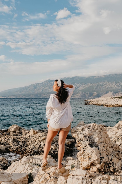 Vue arrière d'une jeune femme en chemise blanche debout sur la plage style de vie d'été mer