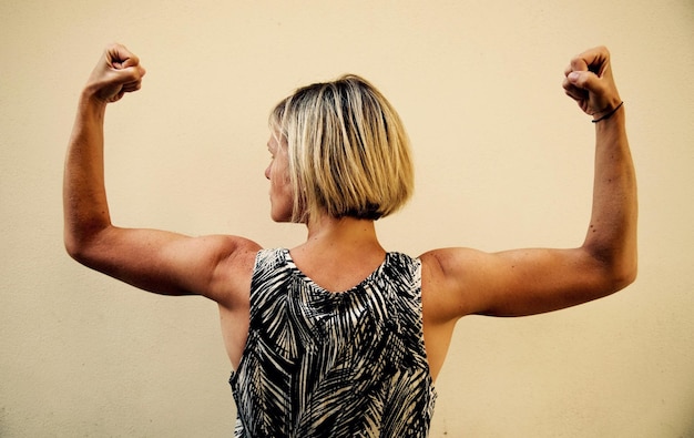 Vue arrière d'une jeune femme debout contre le mur