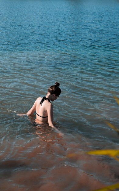 Photo vue arrière d'une jeune femme en mer