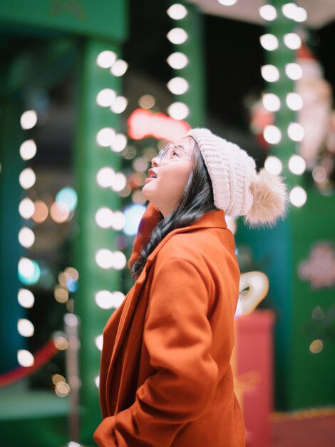 Photo vue arrière d'une jeune femme tenant un arbre de noël la nuit