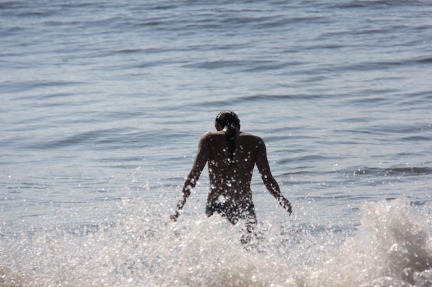 Vue arrière d'une jeune femme en train de profiter de la mer