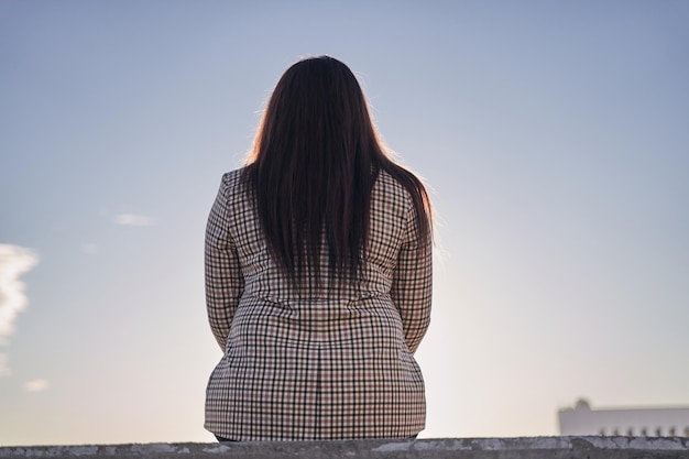 Vue arrière d'une jeune fille brune La femme d'affaires prend une pause dans sa vie bien remplie pour se reposer et réfléchir