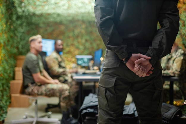 Vue arrière d'un jeune homme de sécurité ou d'un entraîneur en uniforme gris