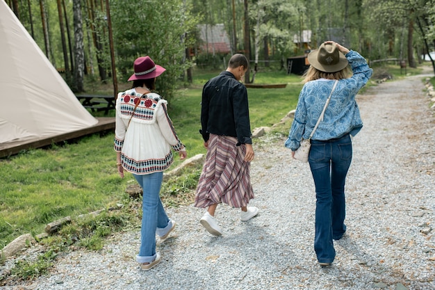 Vue arrière des jeunes marchant sur le camping du festival bénéficiant du beau temps