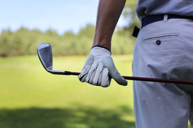 Vue arrière d'un joueur de golf masculin sur le parcours vert.