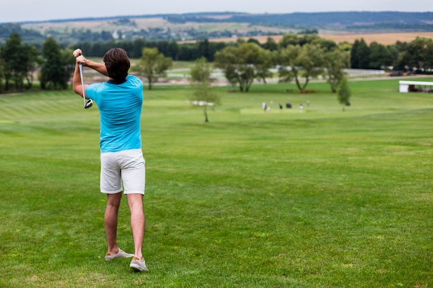 Photo vue arrière joueur de golf sur parcours de golf professionnel