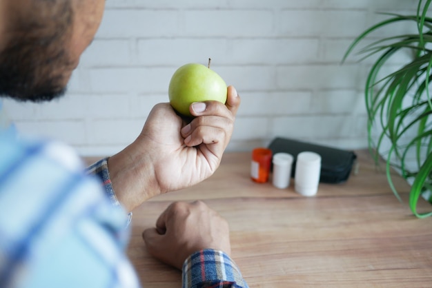 Vue arrière de la main du jeune homme tenant la pomme verte