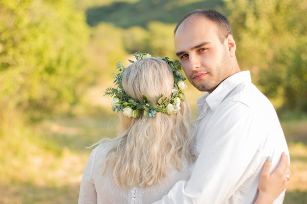 Photo vue arrière sur la mariée et le marié se tenant la main dans une journée d'été ensoleillée mariage en plein air et relationsheep