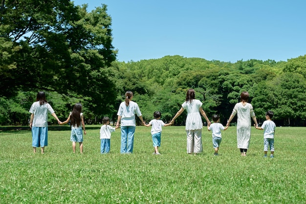 Photo vue arrière de parents et d'enfants alignés dans un champ