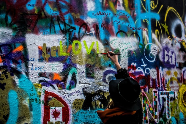 Vue arrière de la peinture de la personne sur le mur de John Lennon