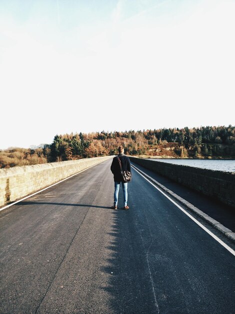 Photo vue arrière d'une personne debout sur la route contre le ciel