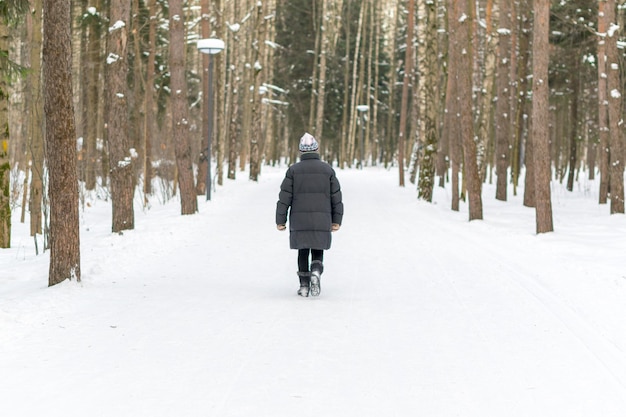 Vue arrière d'une personne marchant sur un paysage couvert de neige