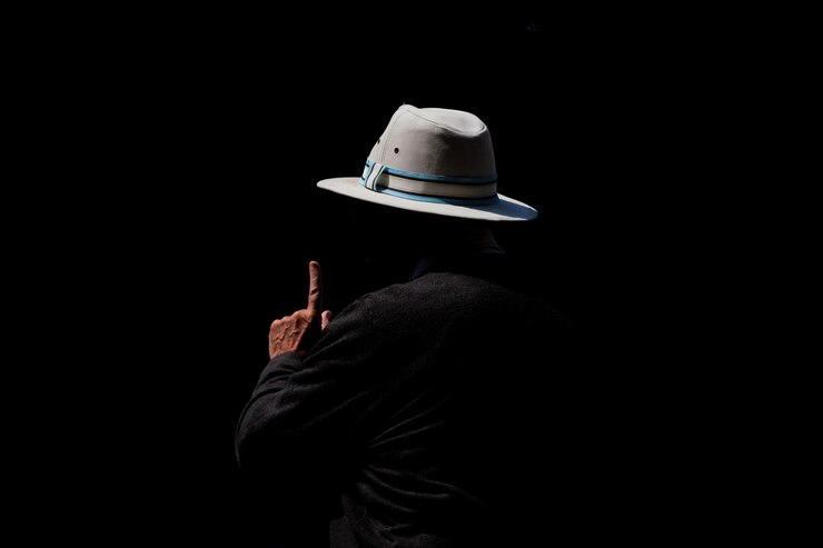 Photo vue arrière d'une personne portant un chapeau sur un fond noir