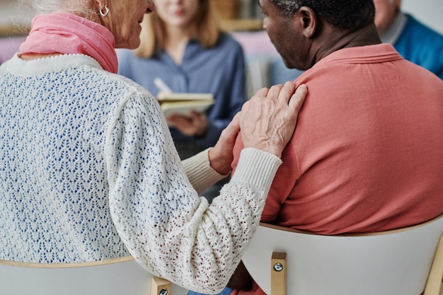 Vue arrière de personnes âgées apprenant à se soutenir pendant la psychothérapie avec un spécialiste