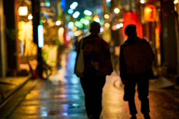 Vue arrière de personnes marchant dans la rue la nuit