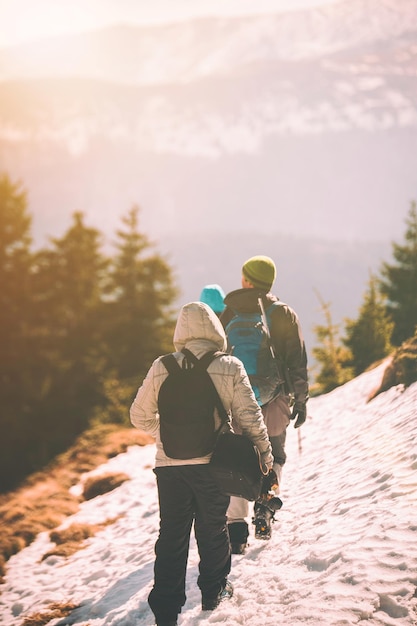 Vue arrière de personnes marchant sur une montagne couverte de neige