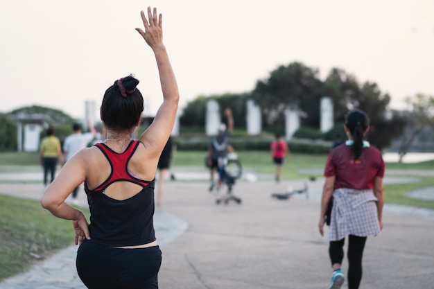 Vue Arrière De Personnes Mûres En Bonne Santé Faisant De L'aérobic Dans Le Parc De La Ville Le Soir Après Le Travail Pour Se Détendre Et Avoir Une Vie Saine. Sports Et Loisirs